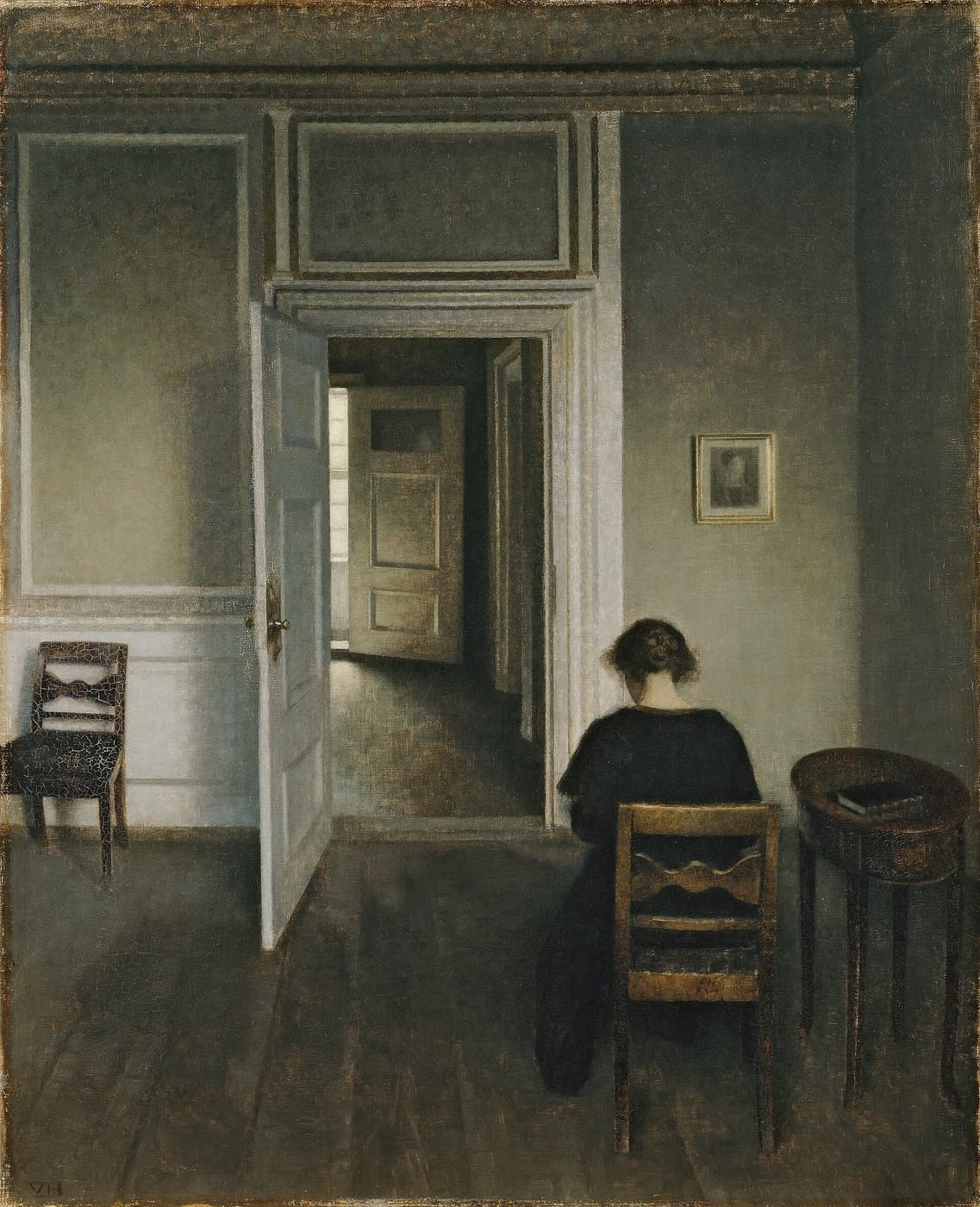 Hammershøi, Interior, Strandgade 30: a door stands open and a woman sits at a table with her back turned.